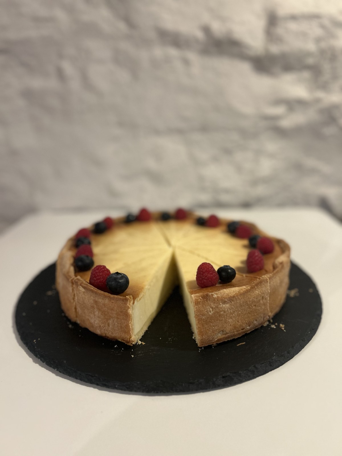 Hausgemachter Cheesecake mit Beerendekoration